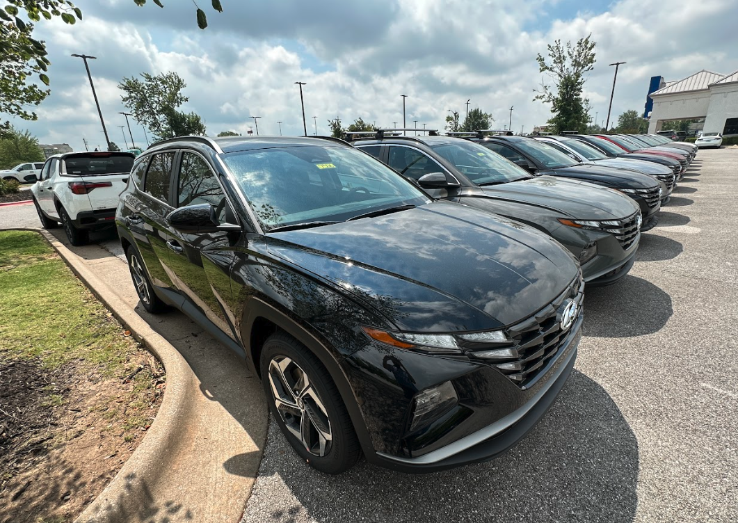 Row of new Hyundai SUVs at Crain Hyundai of Bentonville dealership lot on a sunny day